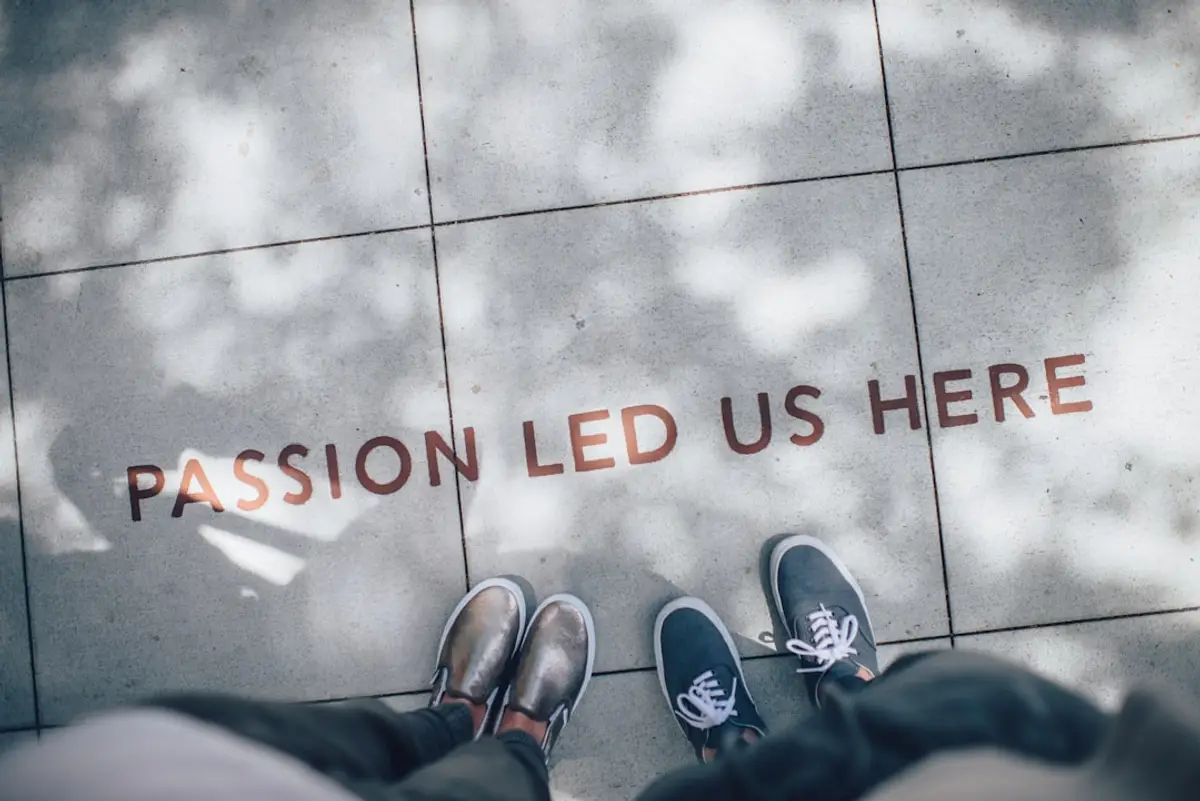 two pairs of shoes on pavement with text 'passion led us here' in lowercase letters